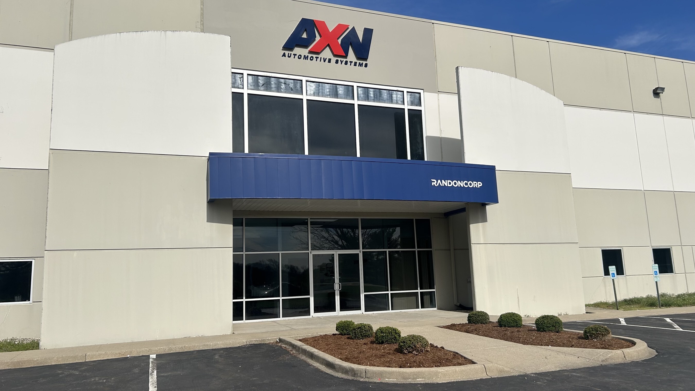 AXN Automotive Systems storefront with blue awning and glass entrance doors