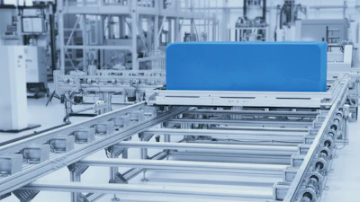 Blue component on industrial conveyor system with metal rails and machinery