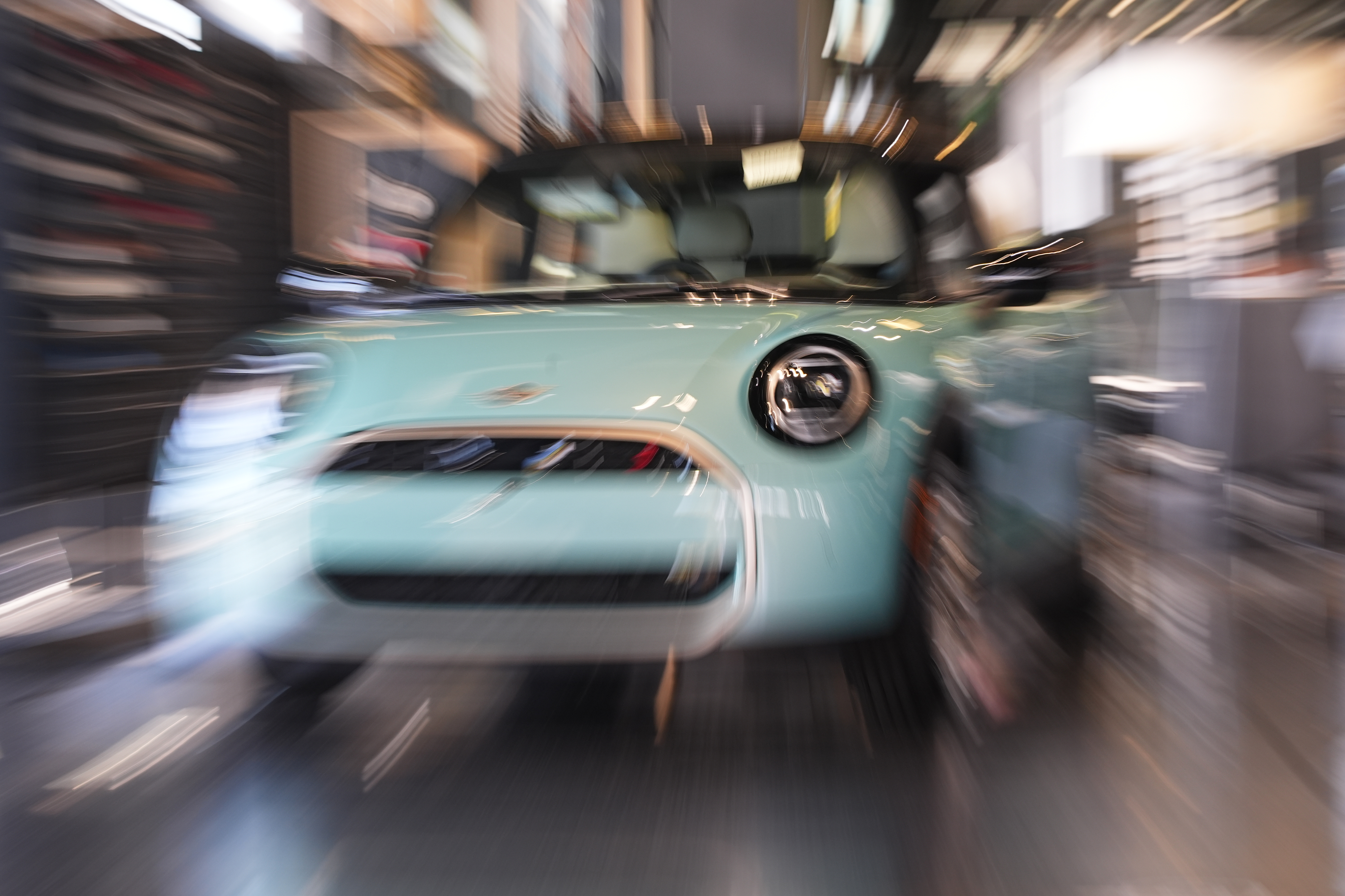 Light blue vintage car displayed in showroom with motion blur effect