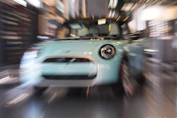 Light blue vintage car displayed in showroom with motion blur effect