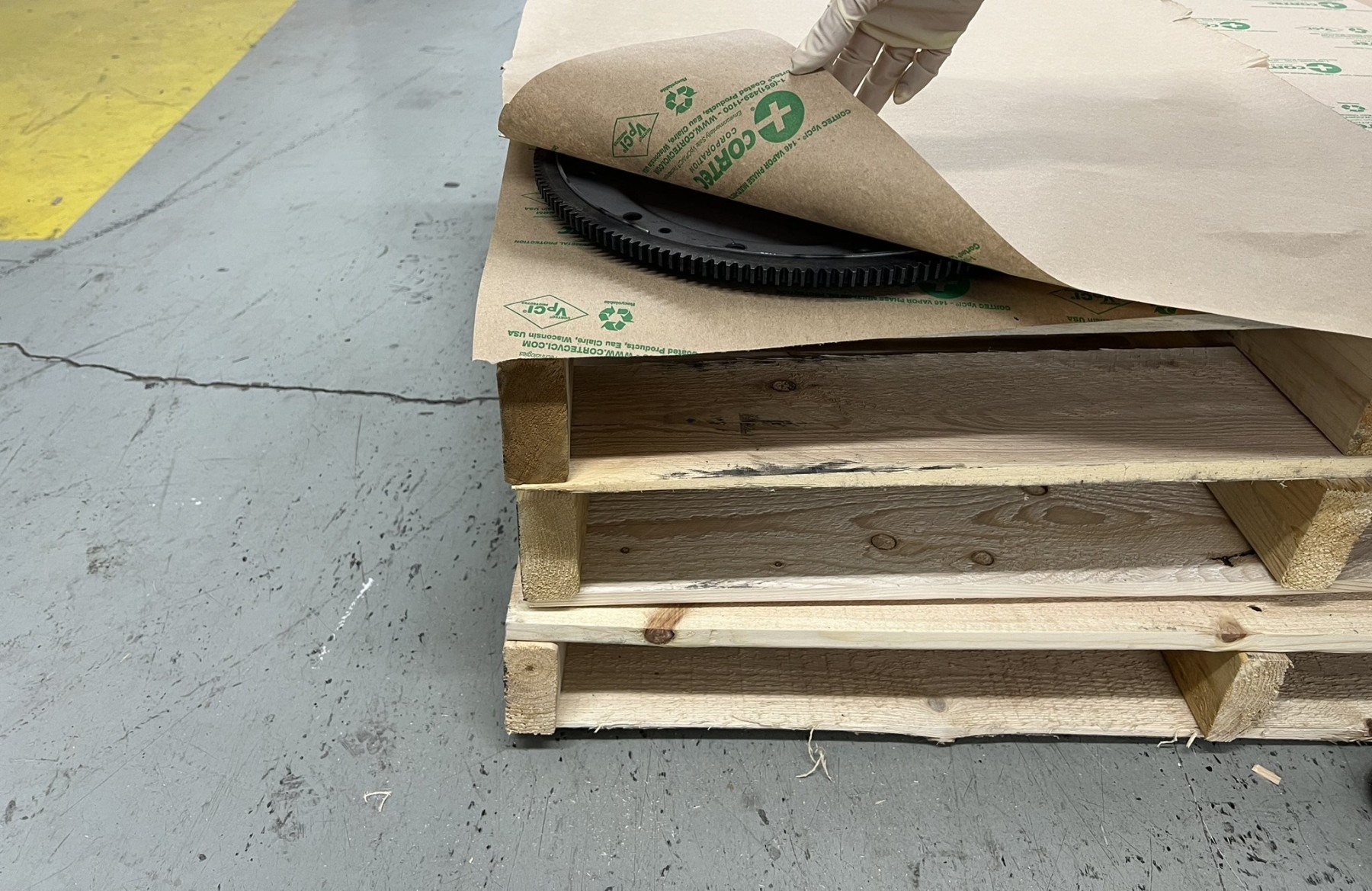 Wooden pallets with protective kraft paper during flooring installation on concrete surface