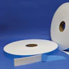 Rolls of white and blue foam weather stripping tape displayed on blue background