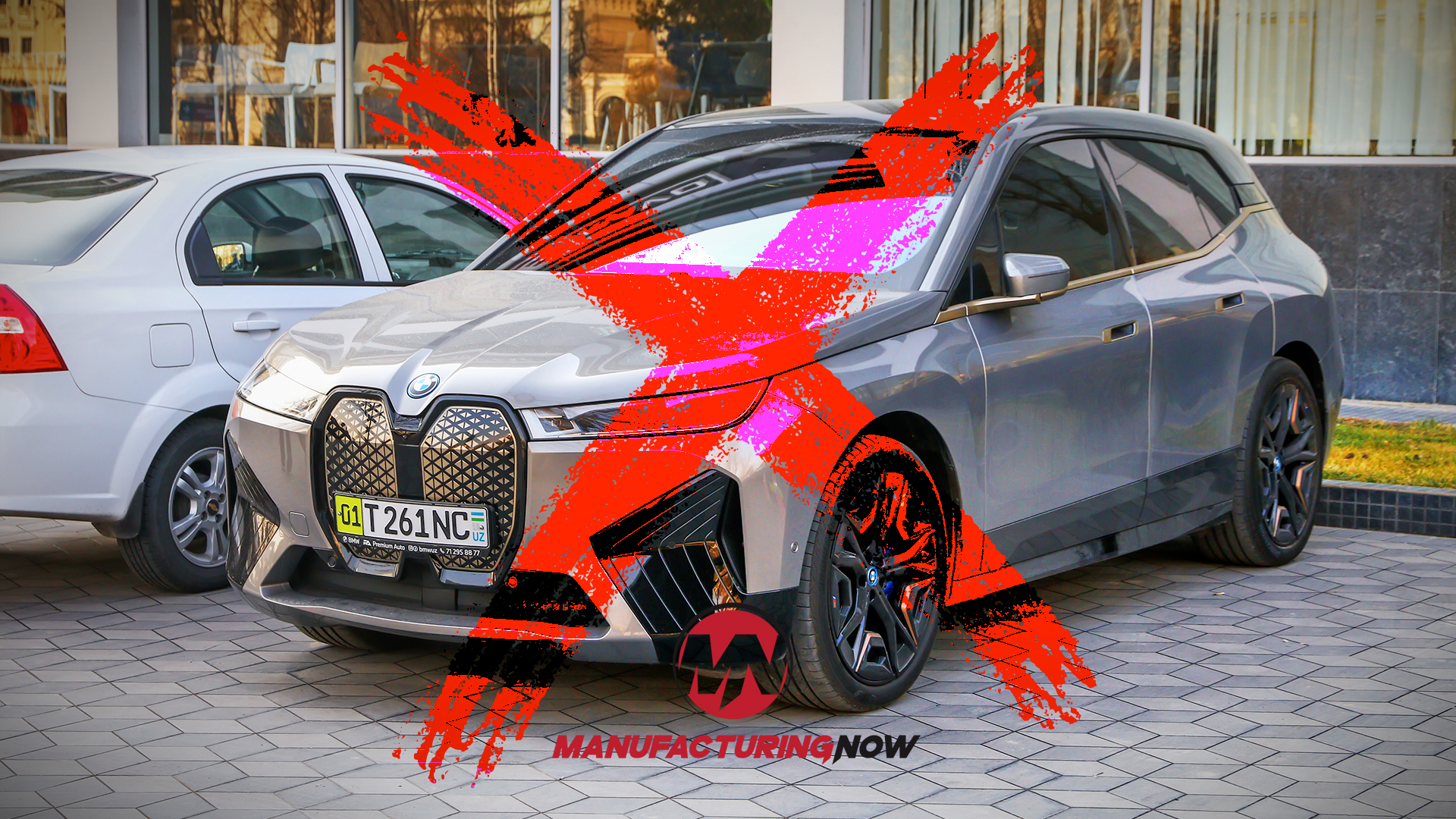 BMW luxury sedan with red decorative bow in showroom with Manufacturing Now branding