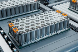 Industrial battery modules with orange accents mounted on gray vehicle platform