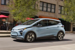 Light blue Chevrolet electric SUV parked on urban street with ivy-covered building facade