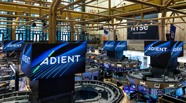 ADIENT branded displays and signage at a large indoor trade show or event venue with industrial architecture