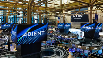 ADIENT branded displays and signage at a large indoor trade show or event venue with industrial architecture