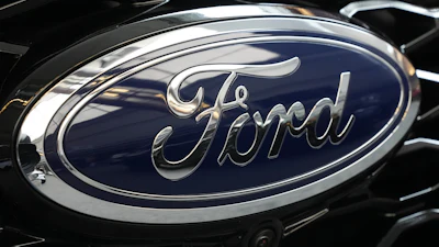 Ford logo emblem on vehicle hood with dark blue background and chrome trim