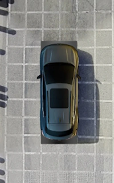 Overhead view of dark sedan parked in marked parking space on concrete surface