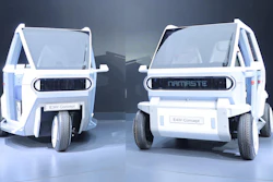 Two white E4W Concept electric vehicles displayed side-by-side with open doors in a modern showroom