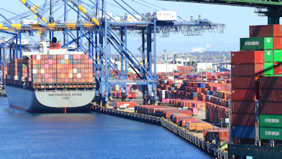 Container ship docked at busy port terminal with stacked cargo containers and loading cranes