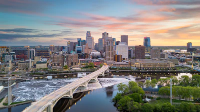 Minneapolis skyline at sunset with Stone Arch Bridge spanning the Mississippi River