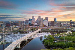 Minneapolis skyline at sunset with Stone Arch Bridge spanning the Mississippi River