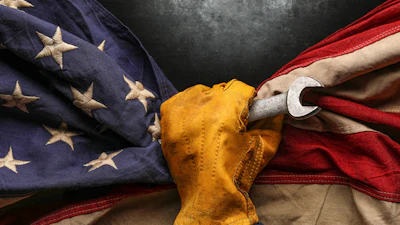 Hand holding folded American flag with yellow cloth against dark background