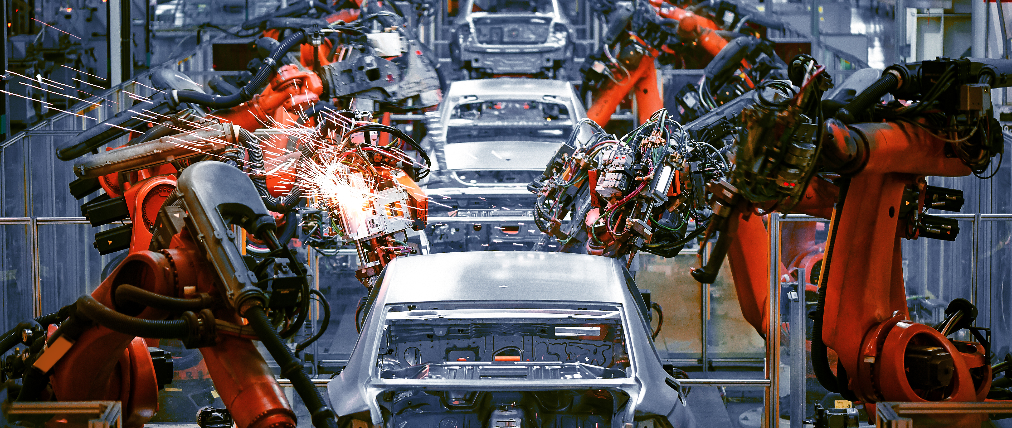 Robotic welding arms assembling white vehicles on an automotive manufacturing production line