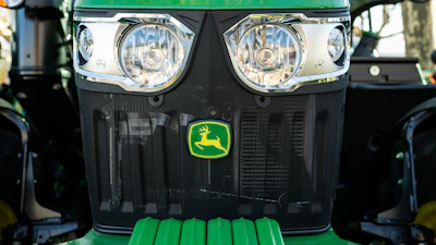 Green John Deere tractor front view with dual headlights and yellow deer logo