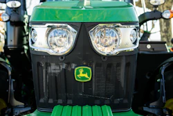Green John Deere tractor front view with dual headlights and yellow deer logo