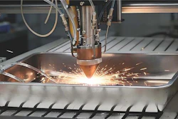 Industrial laser cutting machine creating bright sparks while cutting through metal sheet material