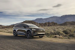 Silver Cadillac Lyriq electric SUV parked in desert landscape with rocky mountains