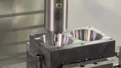 CNC press machine with cylindrical punch tool positioned above metal workpiece with two circular cavities