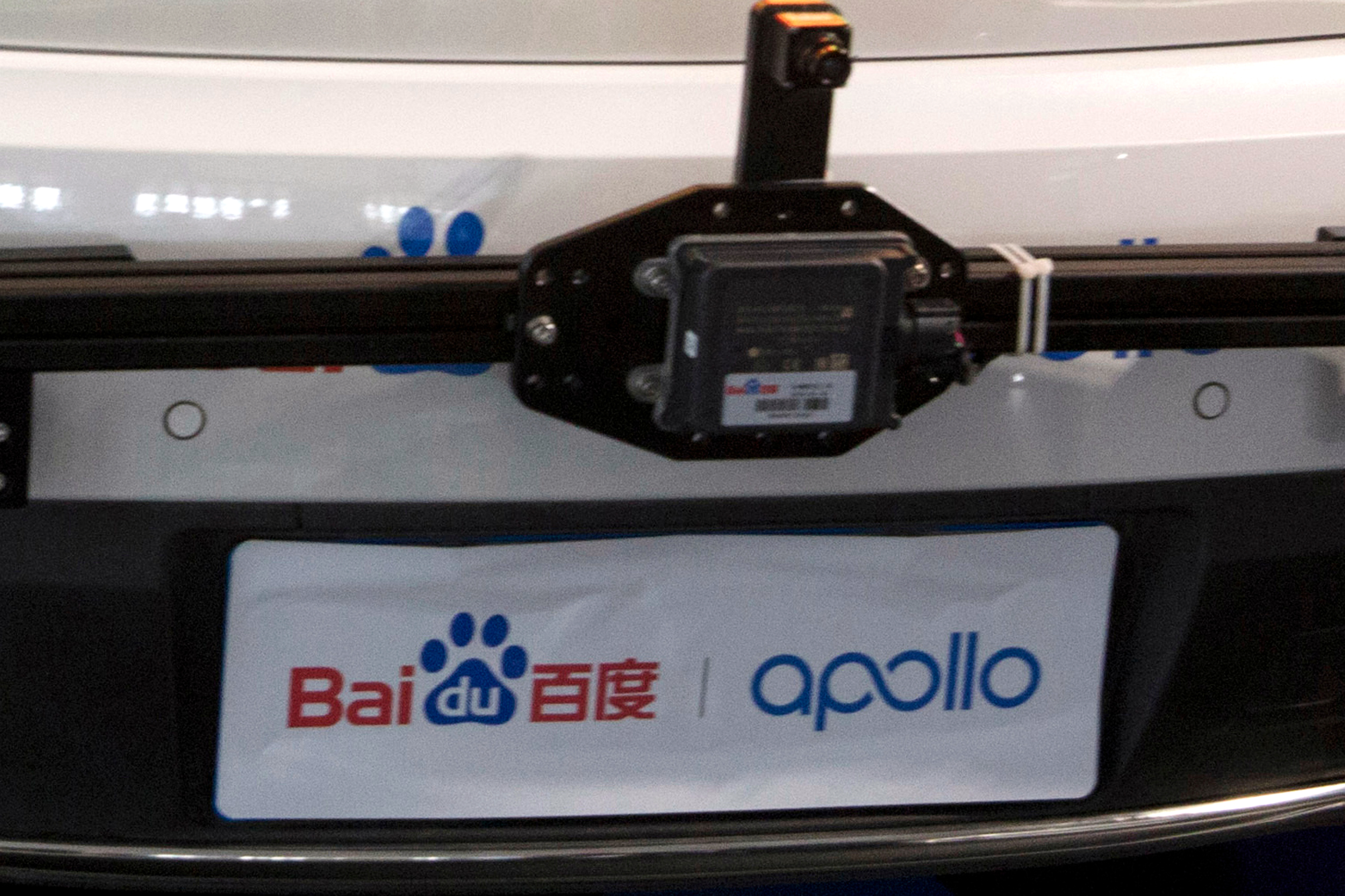 Baidu Apollo autonomous vehicle dashboard with windshield-mounted camera and branding banner