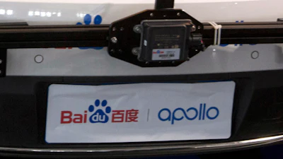 Baidu Apollo autonomous vehicle dashboard with windshield-mounted camera and branding banner