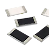 Five surface-mount resistor components with metallic end caps and black or white resistive elements arranged on white background.