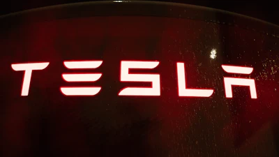 Tesla neon sign glowing red and white against dark background