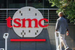 TSMC logo displayed on corporate building signage with person walking past modern facility