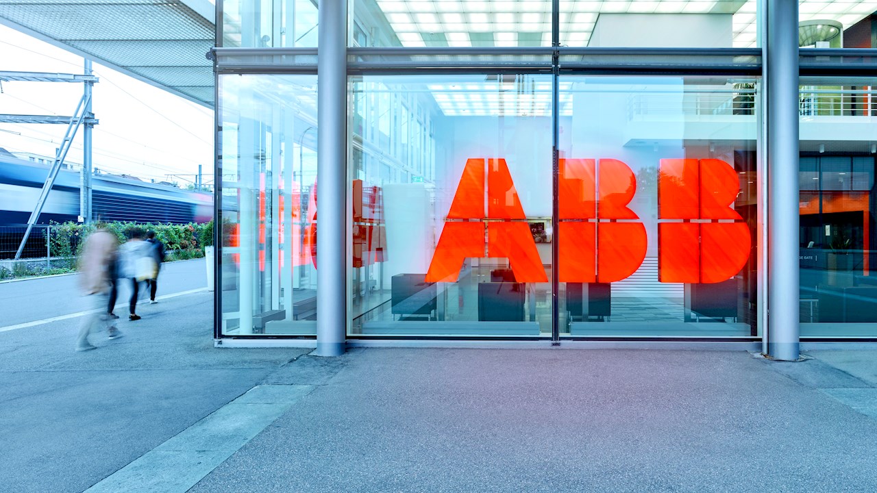 ABB red logo signage on glass storefront with urban street and pedestrians