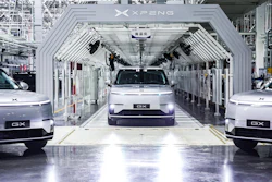 XPENG electric vehicles on assembly line in modern manufacturing facility with white industrial architecture
