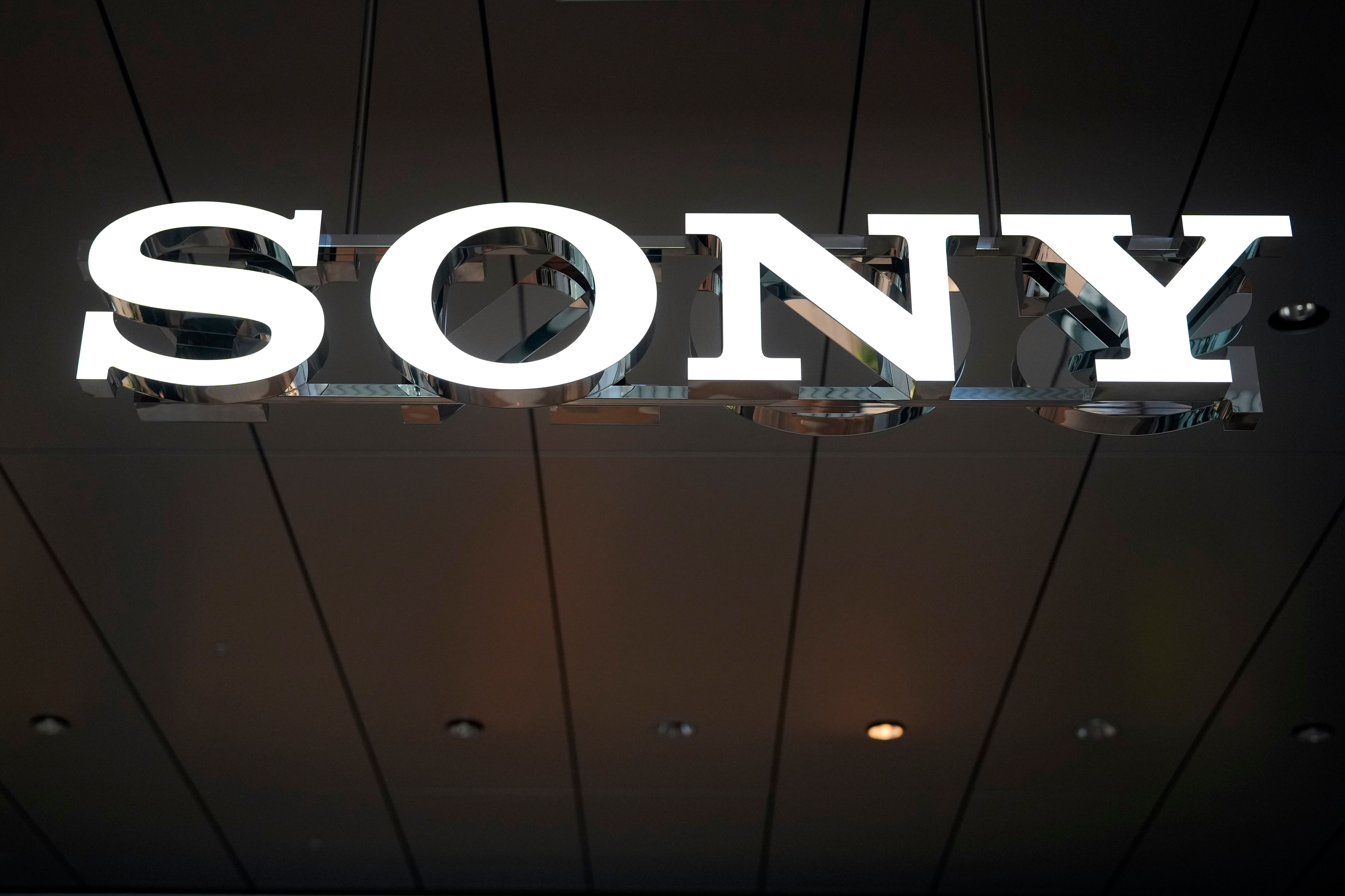 Sony illuminated sign displayed on dark ceiling with metal framework
