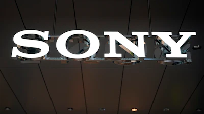 Sony illuminated sign displayed on dark ceiling with metal framework