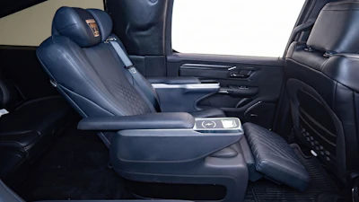 Premium vehicle interior with dark blue leather seats, center console, and modern dashboard controls