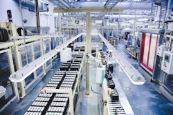 Industrial manufacturing facility with automated production lines, machinery, and storage systems in a modern factory warehouse.