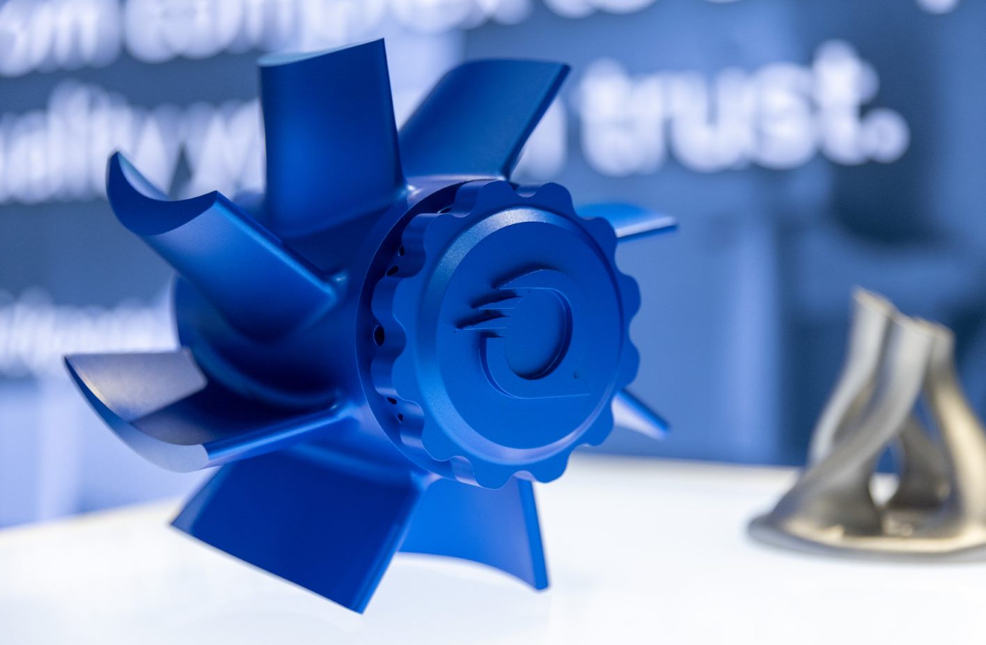 Blue three-dimensional sculptural award or trophy with geometric petal-like design and spiral center element