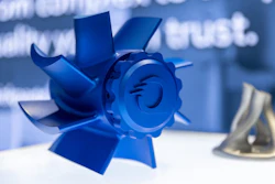 Blue three-dimensional sculptural award or trophy with geometric petal-like design and spiral center element