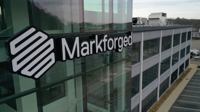 Markforged logo displayed on modern glass building exterior with parking lot visible