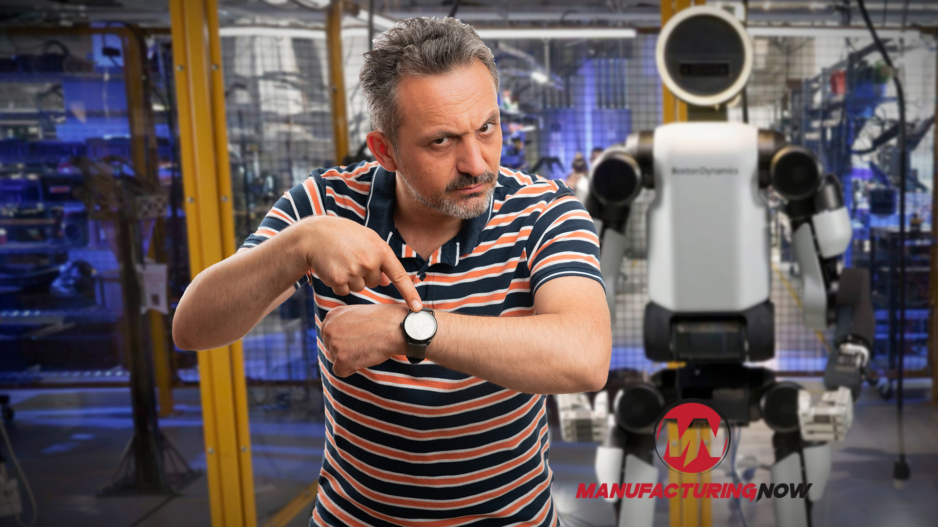 Man in striped shirt demonstrating white robotic device in industrial manufacturing facility