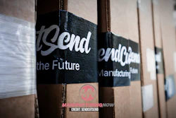 Cardboard shipping boxes with 'Trend' branding and black label bands featuring manufacturing text