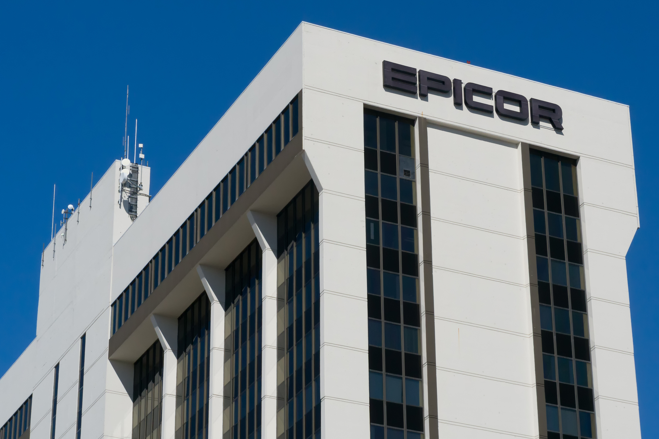 Epicor corporate office building with white facade and black signage against clear blue sky