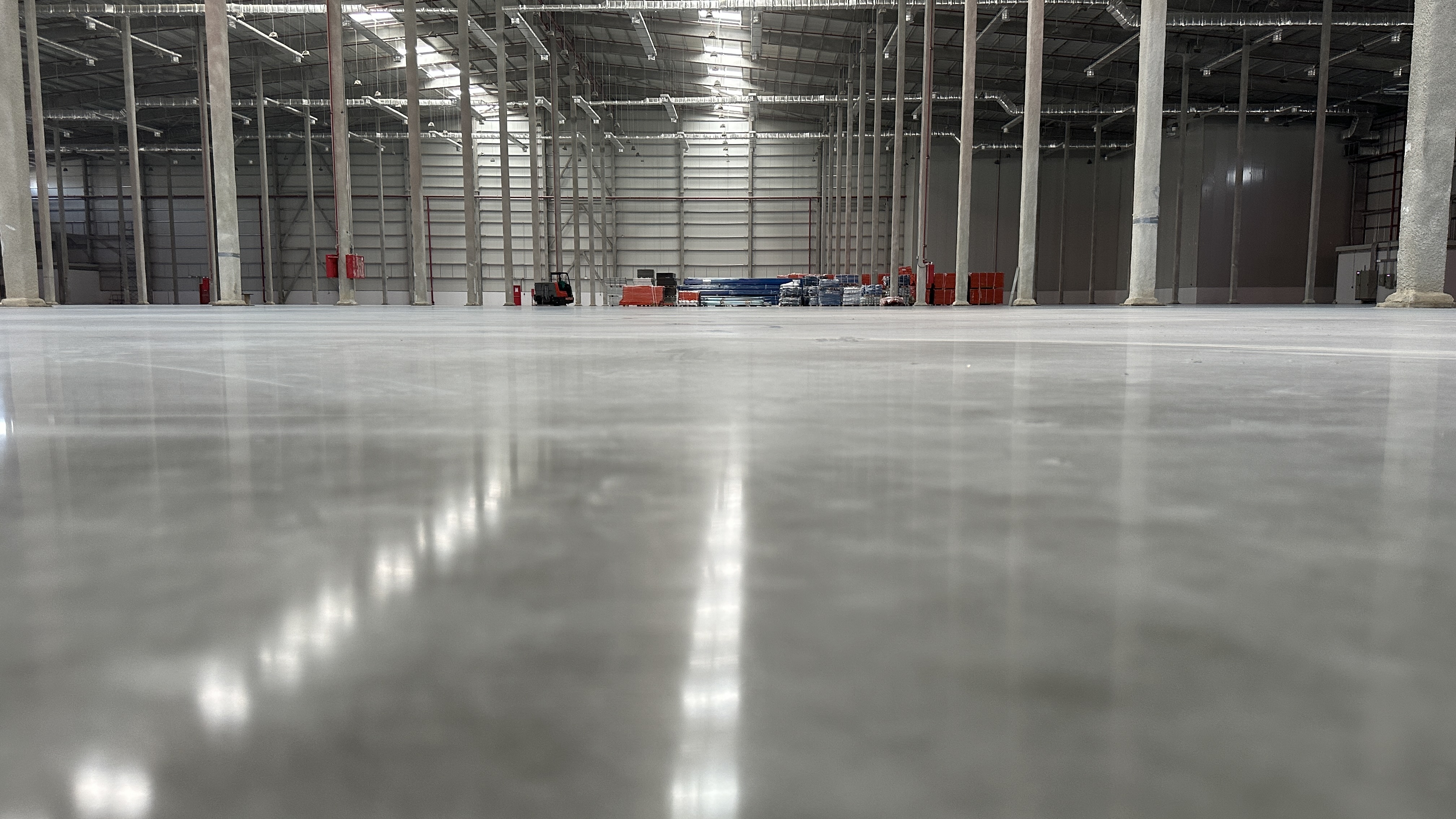 Spacious industrial warehouse with polished concrete floor, metal framework, and glass partitions