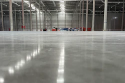 Spacious industrial warehouse with polished concrete floor, metal framework, and glass partitions