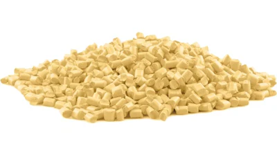 Pile of pale yellow cylindrical pellets or granules on white background