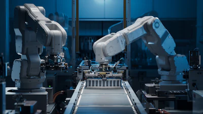 Industrial robotic arms operating on an assembly line with blue ambient lighting in a modern manufacturing facility