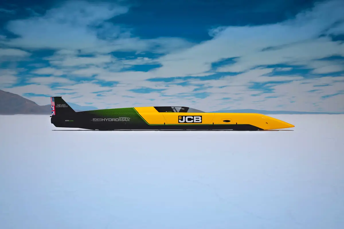 Yellow and black JCB Bloodhound land speed record vehicle on white salt flat under blue sky