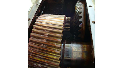 Stack of CDs and DVDs stored in a dark container with metal hardware visible