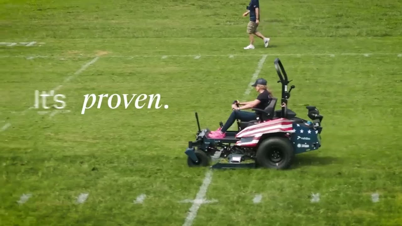 Person operating American flag-themed zero-turn mower on grass field with 'It's proven' text overlay