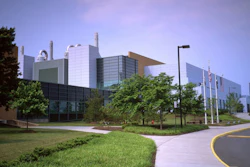 Modern architectural complex with multi-story buildings, green landscaping, and flagpoles along a curved pathway
