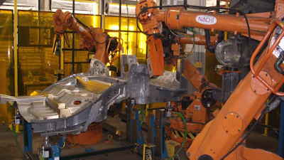 Industrial robotic welding arms with NACHI equipment at manufacturing facility workstation